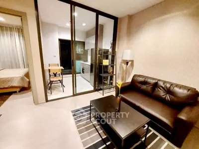 Modern living room with leather sofa and open kitchen layout in stylish apartment