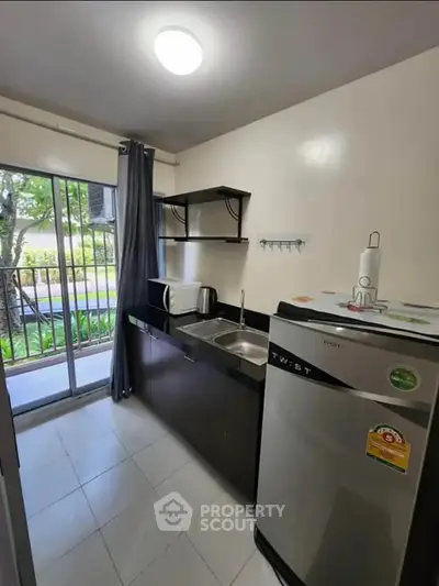 Modern kitchen with stainless steel fridge and garden view