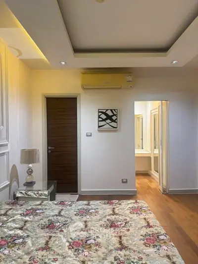 Elegant bedroom with floral bedding and modern decor, featuring an ensuite bathroom.