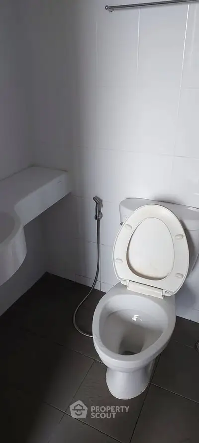 Modern bathroom with sleek white fixtures and tiled flooring, perfect for a minimalist home design.