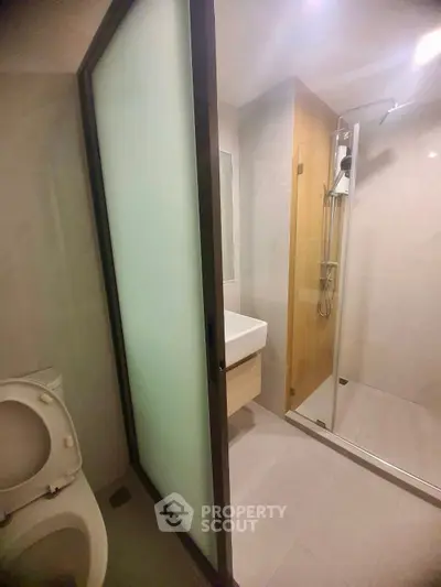Modern bathroom with glass shower and sleek fixtures in a contemporary apartment.