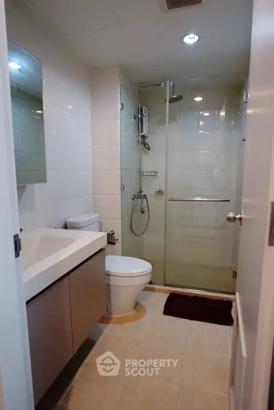 Modern bathroom with glass shower and sleek vanity in a contemporary home.