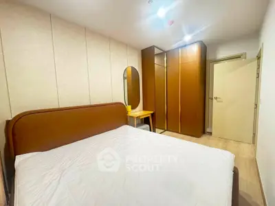Spacious bedroom with modern furnishings and ample storage in a stylish apartment.