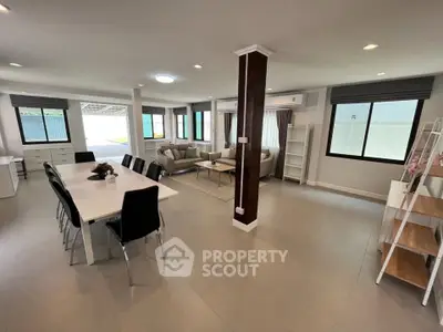 Spacious open-plan living and dining area with modern furnishings and ample natural light.