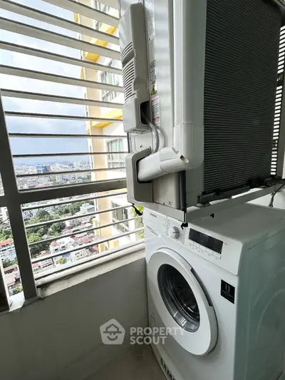 High-rise balcony with washing machine and city view, perfect for urban living convenience.