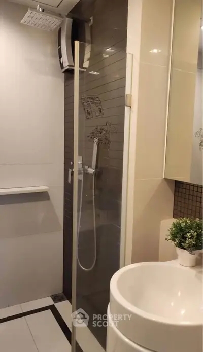 Modern bathroom with sleek shower and stylish sink in contemporary apartment.
