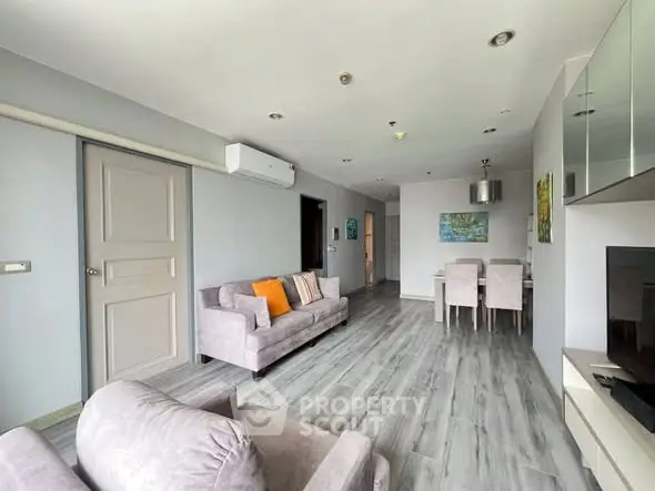 Spacious modern living room with stylish decor and dining area, perfect for comfortable living.