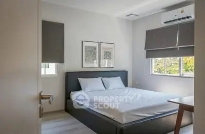 Modern bedroom with sleek design and natural light, featuring a comfortable bed and stylish decor.