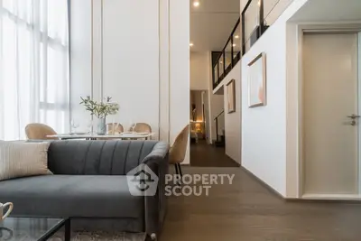 Luxurious modern living room with elegant dining area and high ceilings in a stylish apartment.