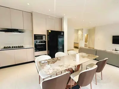 Modern open-layout kitchen and dining area with sleek appliances and elegant decor.