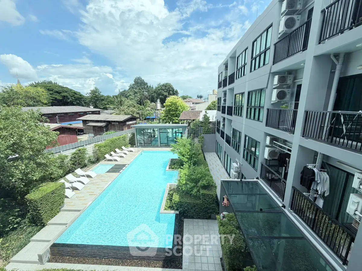 Modern apartment complex with a stunning outdoor pool and lush greenery, perfect for relaxation and leisure.