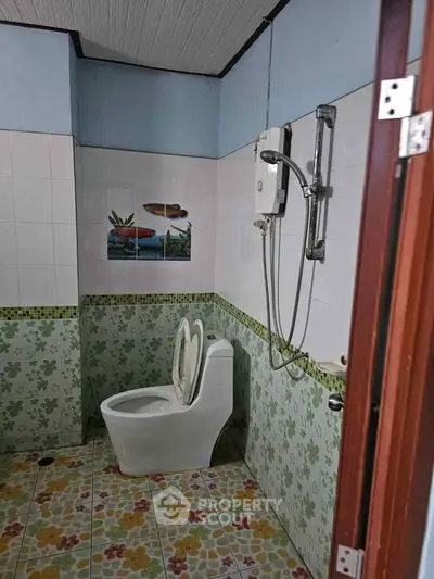 Charming bathroom with floral tiles and modern shower in cozy home.