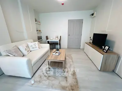 Modern living room with cozy sofa, stylish decor, and sleek TV unit in a bright apartment.