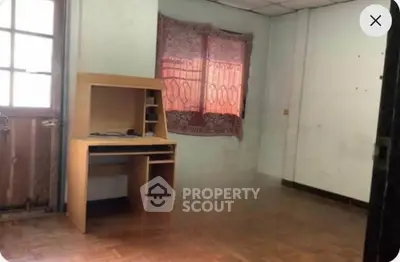 Spacious room with wooden desk and parquet flooring, ideal for home office setup.