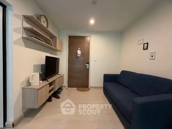 Cozy living room with modern furniture and wall-mounted TV, perfect for relaxation.