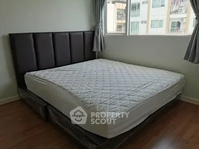 Spacious bedroom with large bed and window view in modern apartment