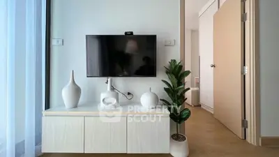 Modern living room with sleek TV setup and stylish decor in a bright apartment.