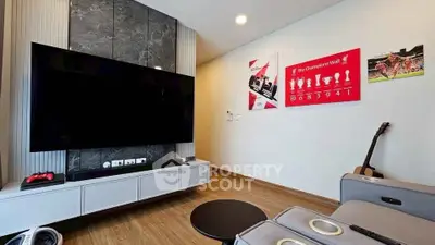 Modern living room with large TV and stylish decor, perfect for entertainment and relaxation.