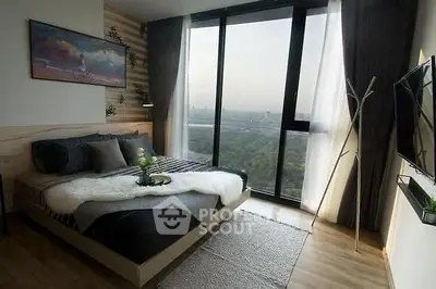 Modern bedroom with large windows offering stunning city views, stylish decor, and cozy ambiance.