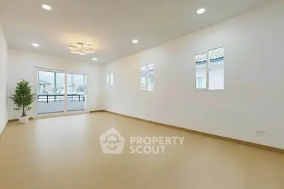 Spacious and bright living room with modern lighting and large windows.