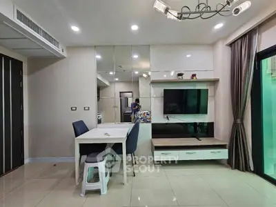 Modern living room with sleek design, featuring a dining area and wall-mounted TV, perfect for urban living.