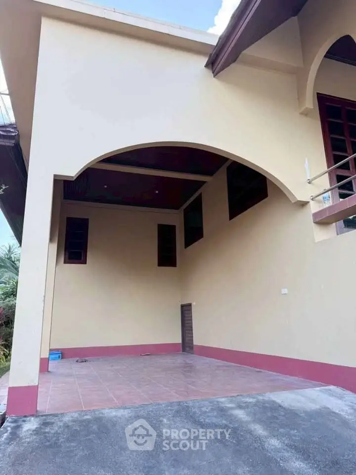 Charming residential entrance with covered parking and elegant archway design.