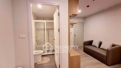 Modern apartment interior with cozy living area and adjacent bathroom.