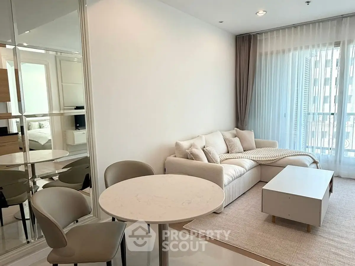 Modern living room with cozy sofa and elegant dining area in a bright apartment.