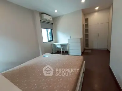 Spacious bedroom with modern furnishings and ample storage in a well-lit apartment.