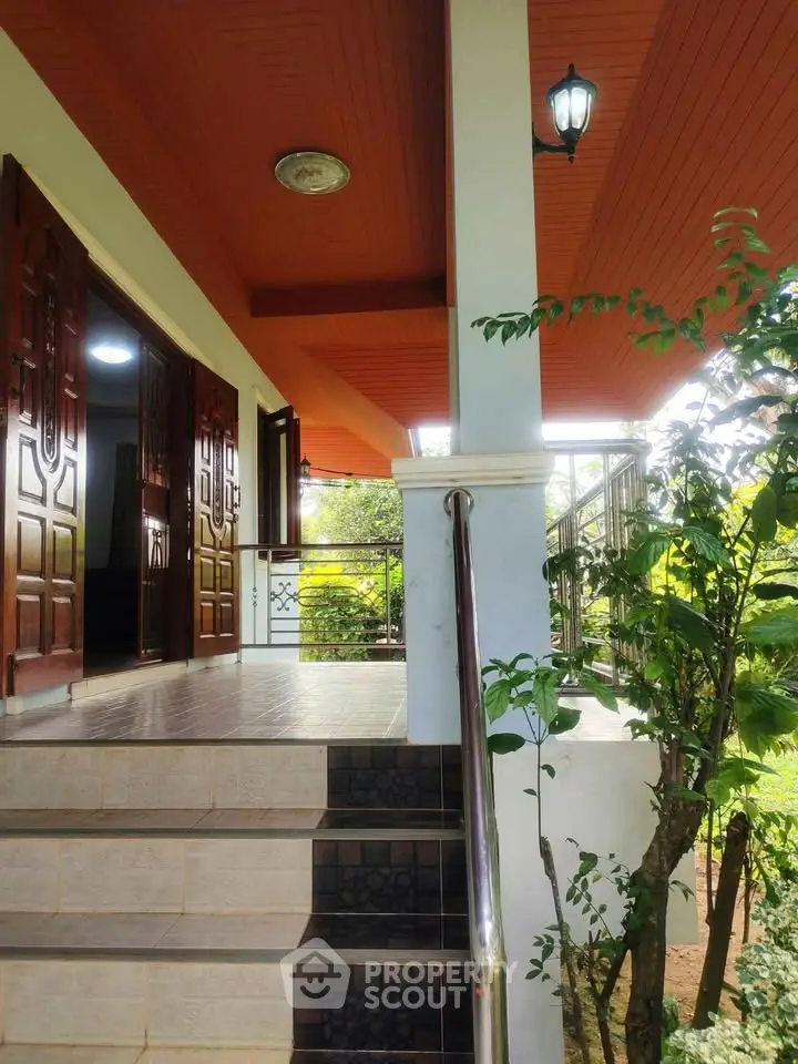Charming home entrance with lush greenery and elegant wooden doors