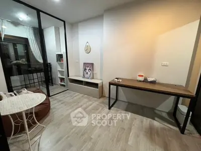 Modern study room with sleek design and wooden flooring, featuring a cozy seating area and stylish decor.
