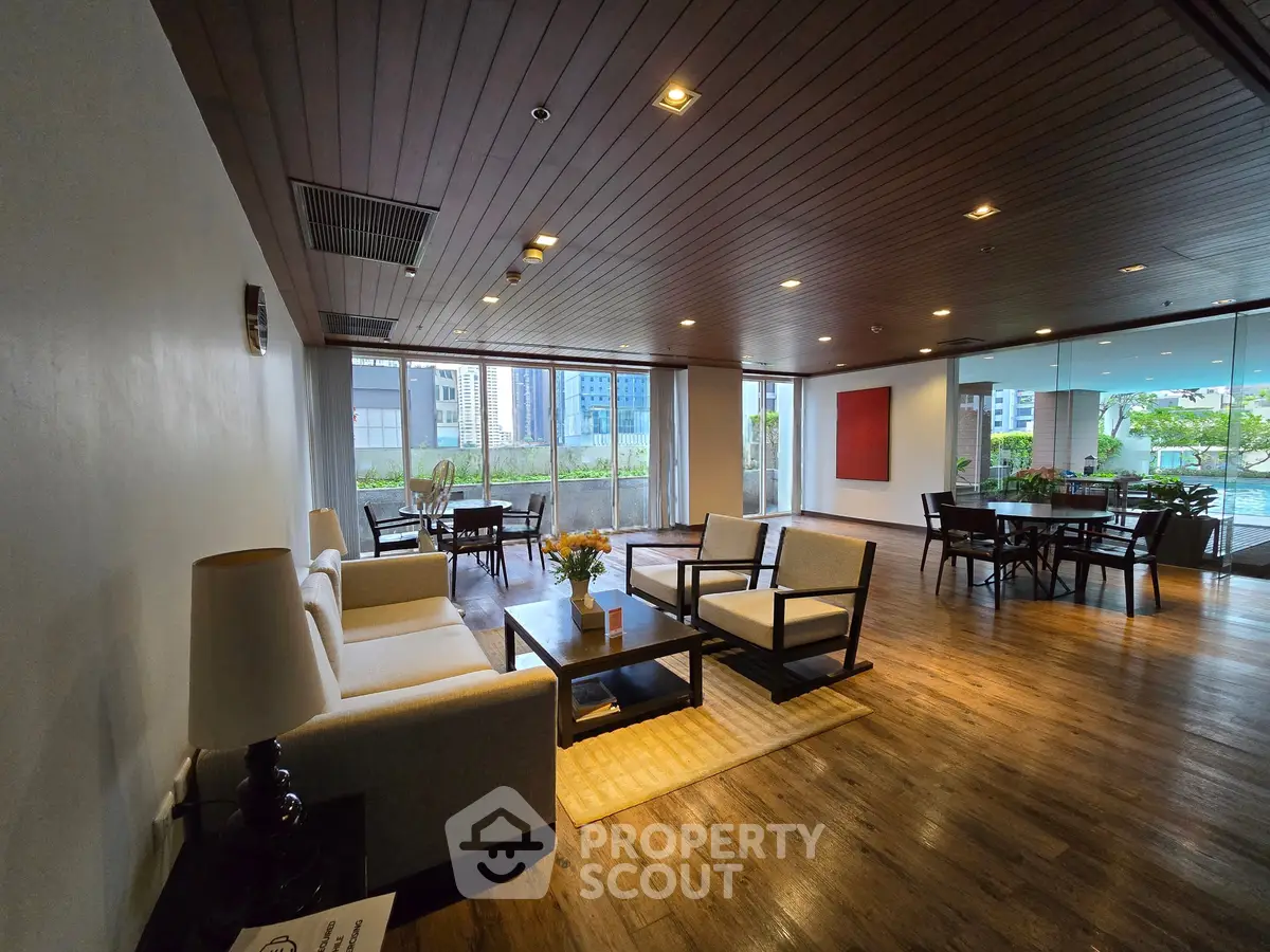 Spacious and elegant living room with modern furniture and large windows offering a garden view.