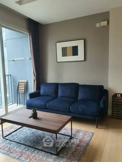 Modern living room with blue sofa and balcony access