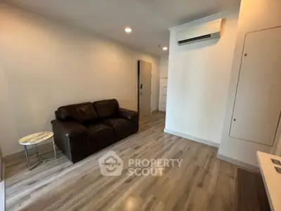 Modern living room with wooden flooring and leather sofa in a cozy apartment