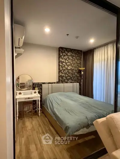 Cozy bedroom with elegant decor and natural light, featuring a stylish vanity and modern furnishings.