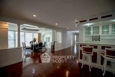 Spacious open-plan living and dining area with elegant wooden flooring and built-in cabinetry.