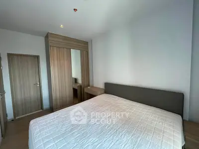 Modern bedroom with sleek wooden wardrobe and cozy bed in a stylish apartment.