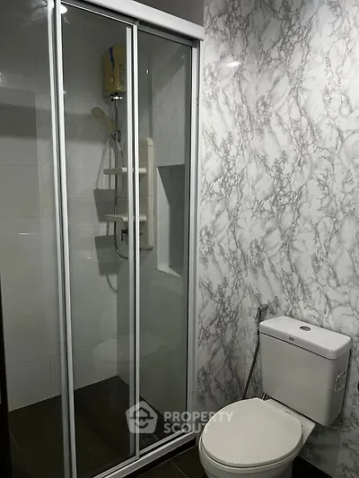 Modern bathroom with sleek shower and marble-patterned walls