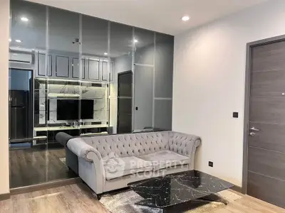 Modern living room with elegant gray sofa and marble coffee table, featuring a mirrored wall and sleek TV unit.