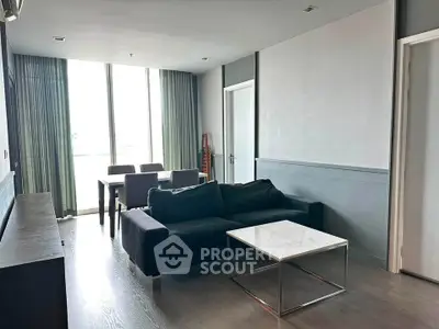 Modern living room with sleek furniture and large windows in a stylish apartment.