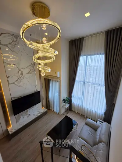 Luxurious living room with high ceilings, elegant chandelier, and modern decor