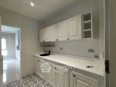 Spacious kitchen with elegant cabinetry and stylish tile flooring, perfect for modern living.