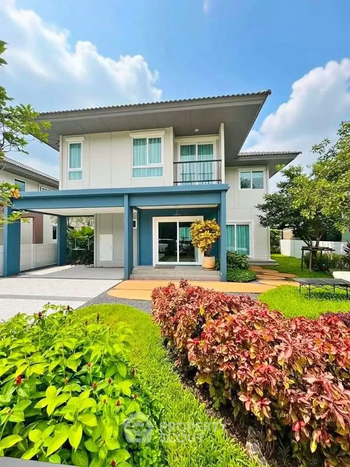 Modern two-story house with lush garden and spacious driveway, perfect for family living.