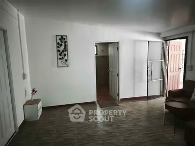 Spacious living room with modern decor and open entrance, perfect for welcoming guests.