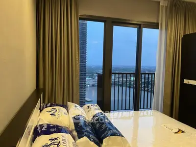 Luxurious bedroom with stunning river view from high-rise balcony, featuring elegant curtains and modern decor.
