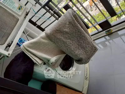 Balcony with washing machine and city view, perfect for urban living convenience.