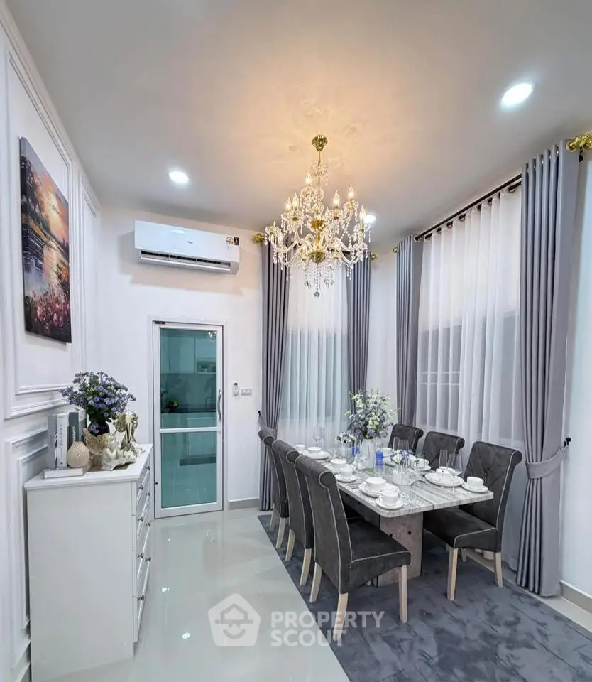 Elegant dining room with chandelier and modern decor, featuring a stylish dining table set and air conditioning.