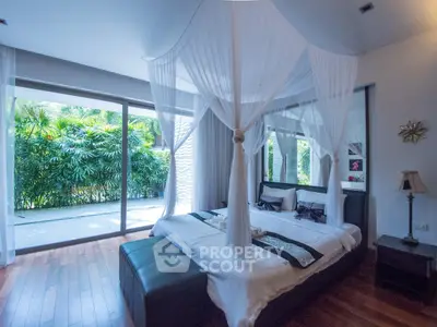 Luxurious bedroom with canopy bed and large windows overlooking lush greenery, perfect for serene living.