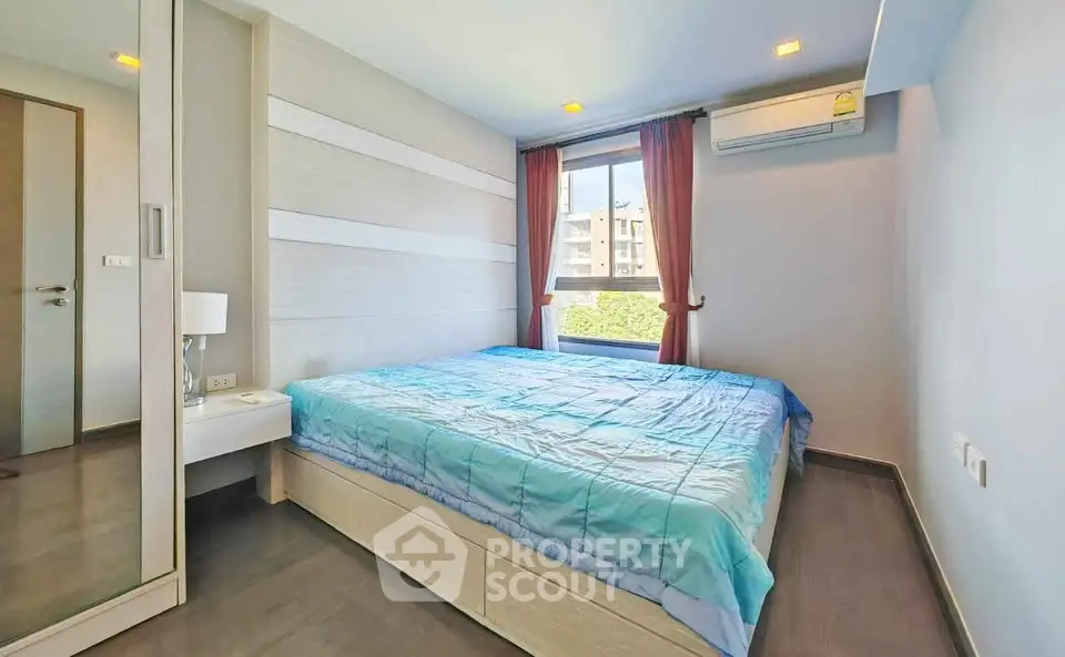 Modern bedroom with large window and air conditioning in stylish apartment