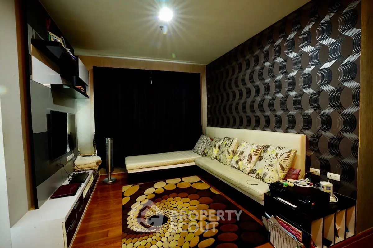 Stylish living room with modern decor and unique wall design, featuring cozy seating and vibrant rug.